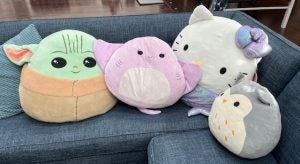Stuffed animals on a couch: baby yoda,stingray, hello kitty, owl